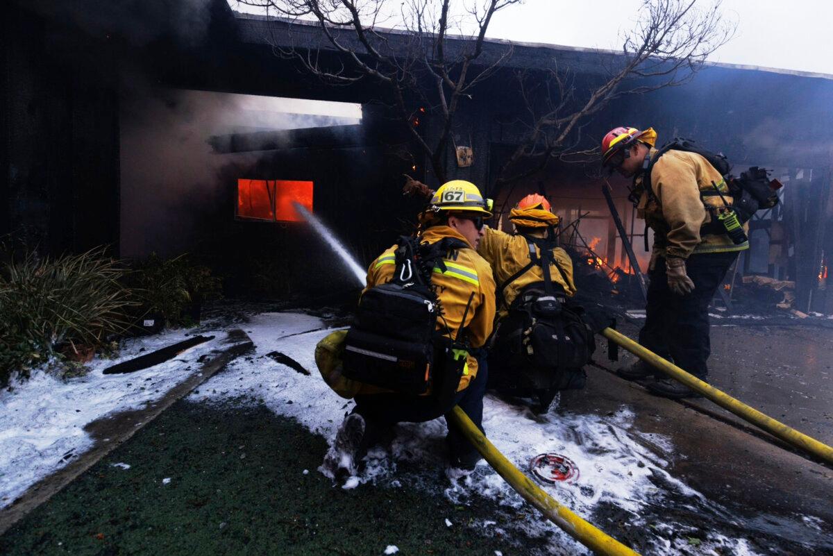 Firefighters battle the advancing Palisades Fire as it damages a residence in the Pacific Palisades neighborhood of Los Angeles on Jan. 7, 2025. (Ethan Swope/AP Photo)