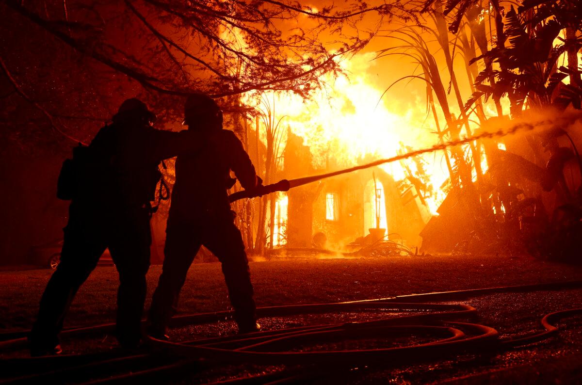 Los Angeles County firefighters spray water on a burning home as the Eaton Fire moved through the area in Altadena, Calif., on Jan. 8, 2025. (Justin Sullivan/Getty Images)