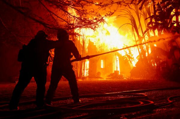 Los Angeles County firefighters spray water on a burning home as the Eaton Fire moved through the area in Altadena, Calif., on Jan. 8, 2025. (Justin Sullivan/Getty Images)
