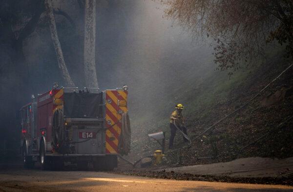 Firefighters work to extinguish the Palisades Fire burning near Los Angeles, Calif., on Jan. 8, 2025. (John Fredricks/The Epoch Times)