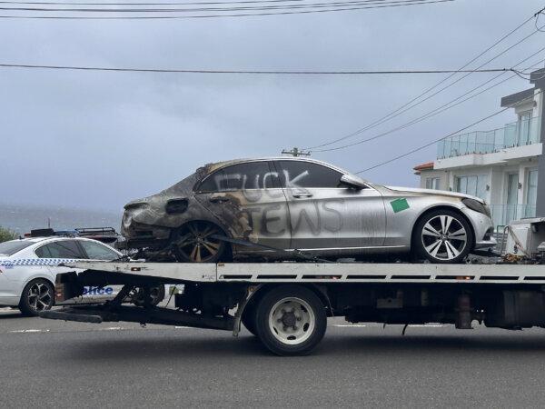 A burnt out car with anti-semitic graffiti is towed away in Dover Heights, Sydney, Australia on Jan. 17, 2025. (AAP Image/Neve Brissendeni)