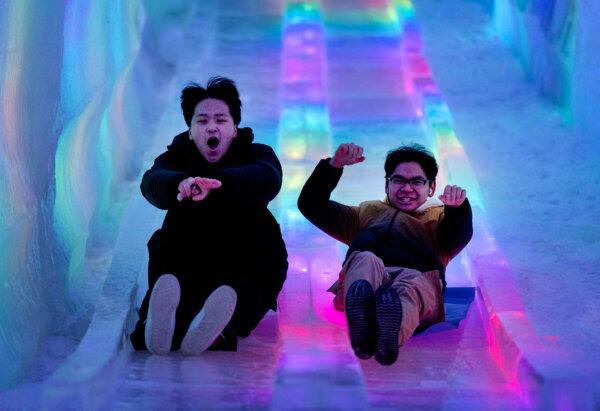 Hideaki Lee, 18, and David Leh, 18, both from St. Paul, make their way down a slide at Minnesota's Ice Castles at The Minnesota State Fair Grounds in Falcon Heights, Minnesota, on Sunday, Jan. 5, 2025. (Carlos Gonzalez/The Minnesota Star Tribune/TNS)