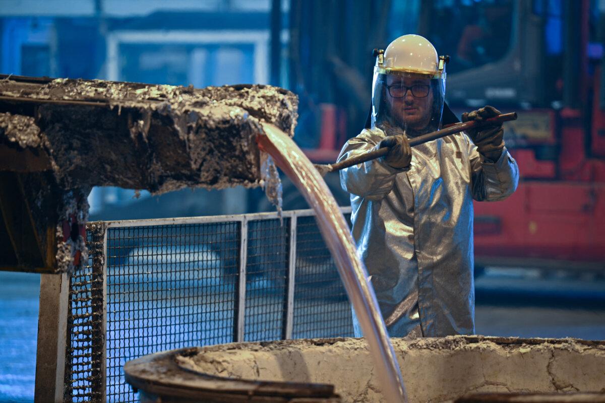 A worker collects molten aluminum samples in Biesheim, France, on Dec. 5, 2022. (Sebastien Bozon/AFP via Getty Images)
