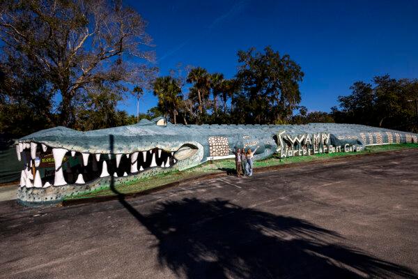 Central Florida explorer Patrick Connolly, left, Karissa Bellile, center, and Maleia Twilla stand in front of Swampy, the world’s largest alligator, outside of Jungle Adventures in Christmas, Fla., on Jan. 1, 2025. (Patrick Connolly/Orlando Sentinel/TNS)