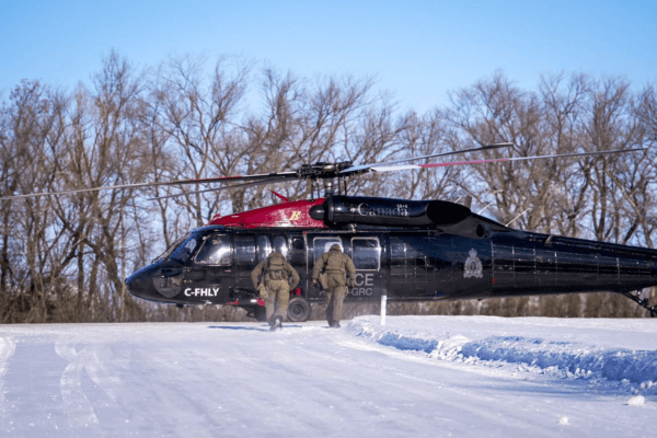 RCMP officers approach one of the force's newly acquired Blackhawk helicopters for patrolling the Canada-U.S. border. (RCMP handout)