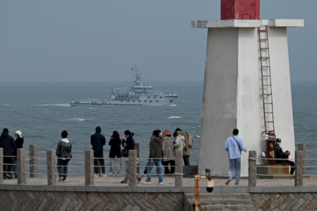 A Chinese navy tugboat sails in the Taiwan Strait, past tourists on Pingtan Island, the closest point to Taiwan, in Fujian Province, China, on April 7, 2023. (Greg Baker/AFP via Getty Images)