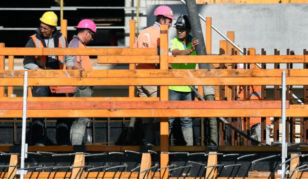 Workers lay concrete at the construction of a new apartment block in Melbourne, Australia, on June 5, 2018. (William West/AFP via Getty Images)