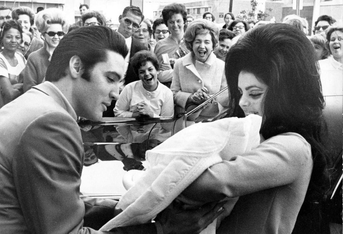 Elvis Presley (L) and Priscilla Presley show off their baby daughter, Lisa Marie, in a publicity still in February 1968. (Public Domain)