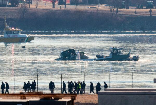 Investigators walk the grounds of the Reagan National Airport as they work near the crash last night of the American Airlines plane on the Potomac River as it approached the Reagan National Airport in Arlington, Va., on Jan. 30, 2025. (Win McNamee/Getty Images)