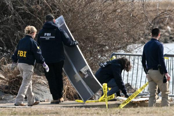 Investigators gather pieces of wreckage along the Potomac River the day after American Airlines flight 5342 on approach to Reagan National Airport crashed into the river after colliding with a US Army helicopter, near Washington on January 30, 2025. (Andrew Caballero-Reynolds/AFP via Getty Images)