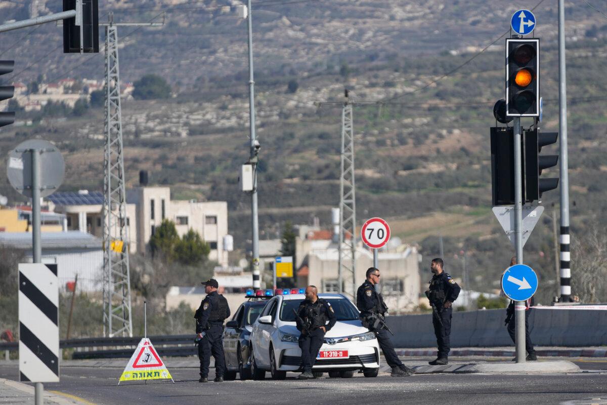 Israeli policemen block a main road after gunmen opened fire on cars and a bus carrying Israelis in the occupied West Bank, killing at least three people, near the Palestinian village of Al-Funduq, on Jan. 6, 2025. (Nasser Nasser/AP Photo)