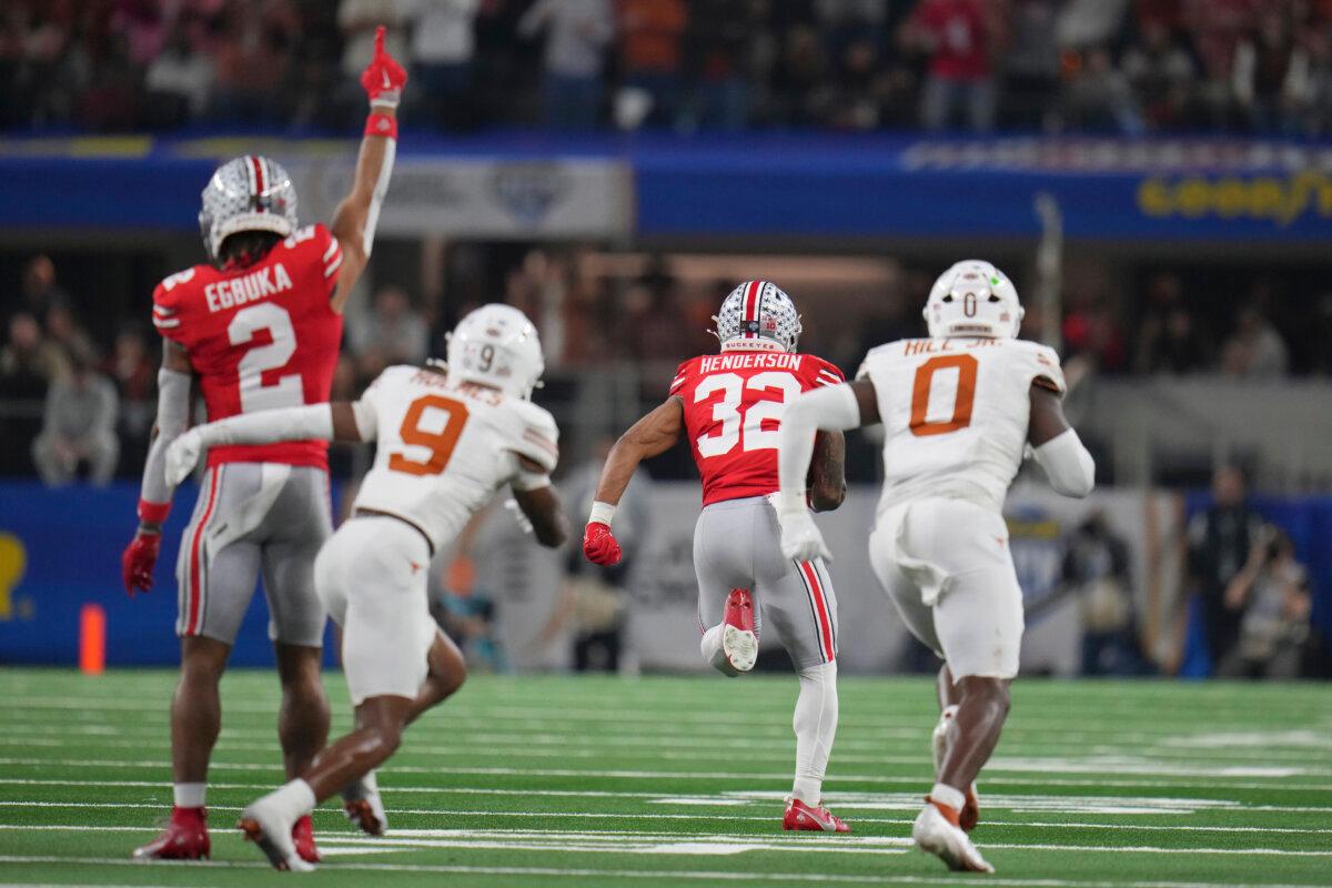 Ohio State wide receiver Emeka Egbuka (2) reacts as running back TreVeyon Henderson (32) runs past Texas defensive back Gavin Holmes (9) and linebacker Anthony Hill Jr. (0) to score during the first half of the Cotton Bowl College Football Playoff semifinal game in Arlington, Texas, on Jan. 10, 2025. (Julio Cortez/AP Photo)