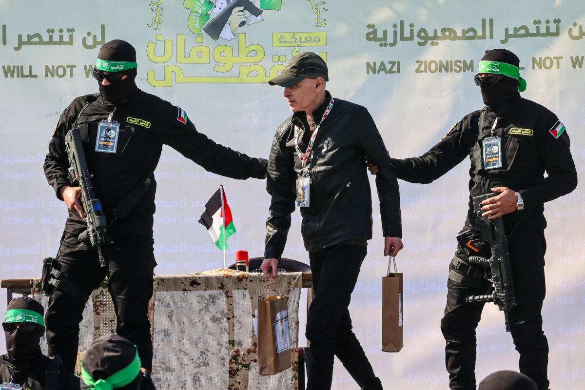 Members of the Palestinian Hamas terrorist group escort American-Israeli hostage Keith Siegel onto a stage before handing him over to a Red Cross team in Gaza City as part of the fourth hostage-prisoner exchange on Feb. 1, 2025. (Omar Al-Qattaa/AFP via Getty Images)