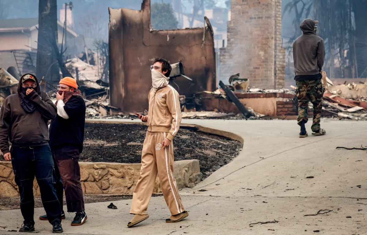 Masked people view damage from the Eaton Fire amid poor air quality in Altadena, Calif., on Jan. 8, 2025. (Mario Tama/Getty Images)
