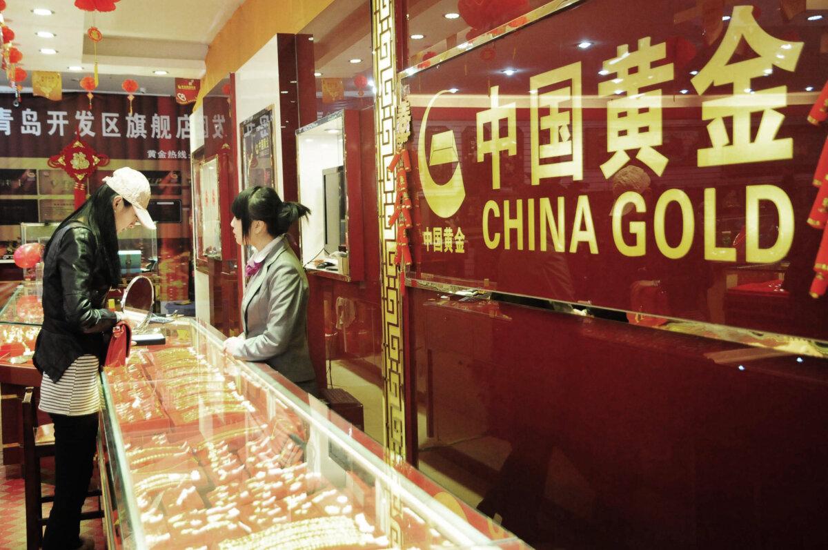 Gold Prices Keep Hitting Record Highs Amid US–China Tariff War 2 A Chinese woman buys gold jewelry at a gold shop in Qingdao, northeast China's Shandong Province, on Feb. 16, 2012. (STR/AFP via Getty Images)