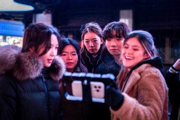 People watch a video recorded for social media, including TikTok, in New York's Times Square on Jan. 14, 2025. (Adam Gray/Getty Images)