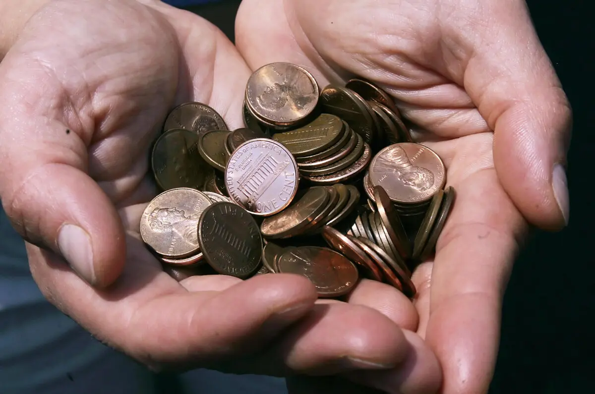 A man shows a handful of the U.S. cent in Washington on July 18, 2006. (Jim Watson/AFP via Getty Images)