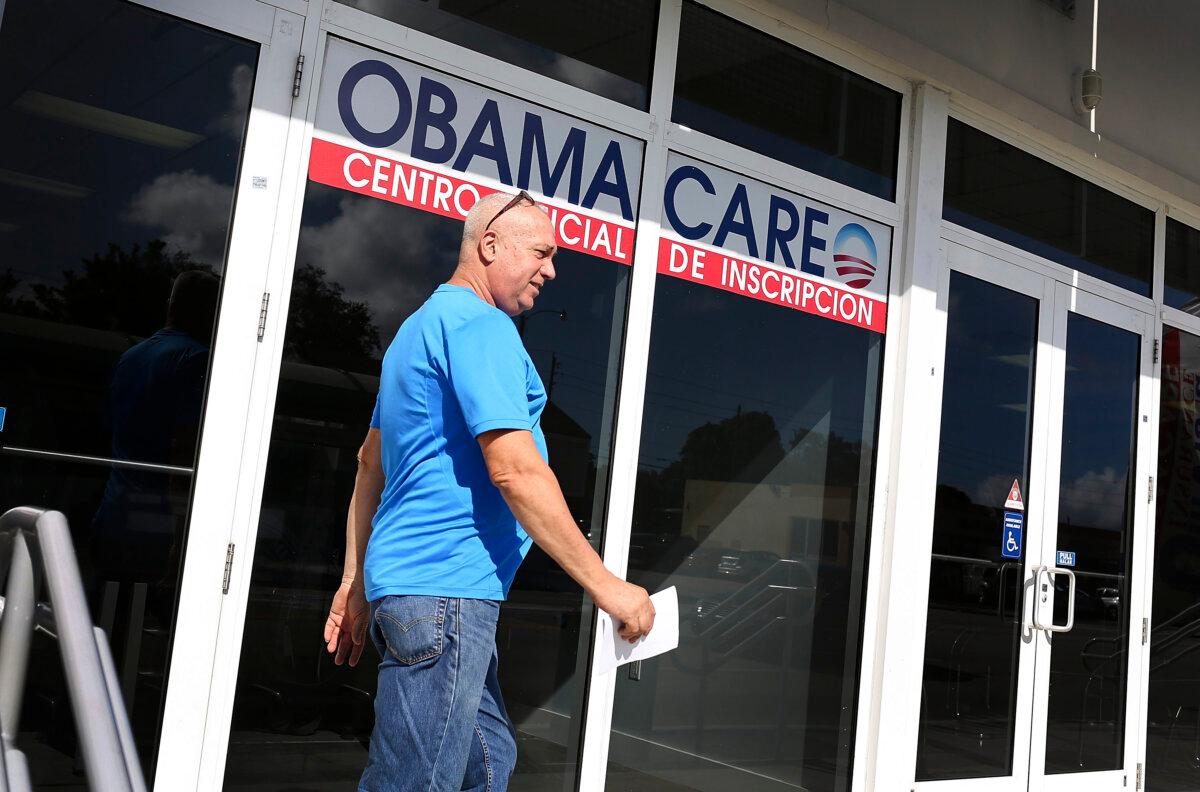 Affordable Care Act Premiums Going Up, New Figures Show | USNN World News A man near an office with a sign about Obamacare, or the Affordable Care Act, in Miami, Fla., in an undated file photograph. (Joe Raedle/Getty Images)