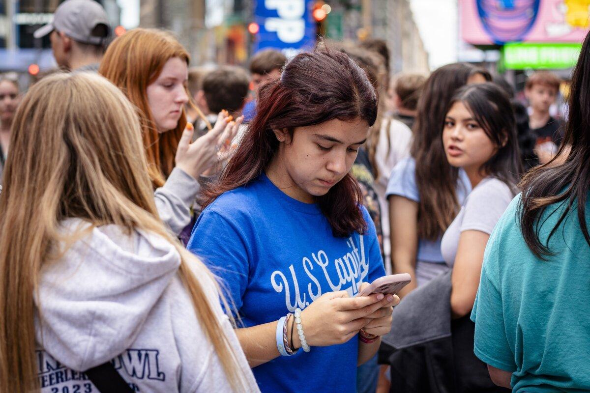 People with their phones in New York City on June 10, 2024. (Samira Bouaou/The Epoch Times)