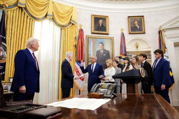 Robert F. Kennedy Jr., joined by his wife, Cheryl Hines, and his family, is sworn in as secretary of Health and Human Services by Supreme Court Justice Neil Gorsuch as President Donald Trump looks on in the Oval Office on Feb. 13, 2025. (Andrew Harnik/Getty Images)