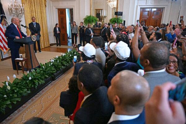 U.S. President Donald Trump speaks alongside U.S. golfer Tiger Woods during a reception for Black History Month in the East Room of the White House in Washington on Feb. 20, 2025. (Jim Watson/AFP via Getty Images)