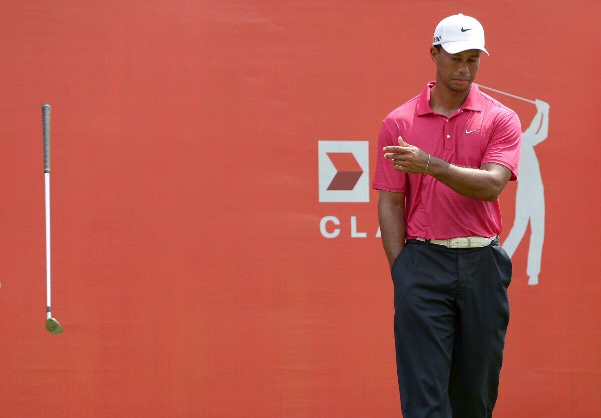 Tiger Woods of the United States throws his club after missing a putt at the 18th hole during the third round of the $6.1 million CIMB Classic golf tournament at The Mines Resort and Golf Club in Kuala Lumpur, on Oct. 27, 2012. (Mohd Rasfan/AFP via Getty Images)