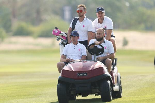Tom McKibbin and Tyrrell Hatton of Team Great Britain & Ireland and their caddies ride a buggy on the 18th hole during a practice round prior to the Team Cup at Abu Dhabi Golf Resort in Abu Dhabi, United Arab Emirates, on Jan. 9, 2025. (Kate McShane/Getty Images)