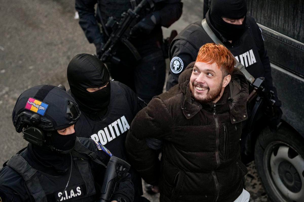 Police officers escort French fugitive Mohamed Amra, nicknamed ''The Fly," after a court hearing at the Court of Appeals in Bucharest, Romania, on Feb. 23, 2025. (Vadim Ghirda/AP)