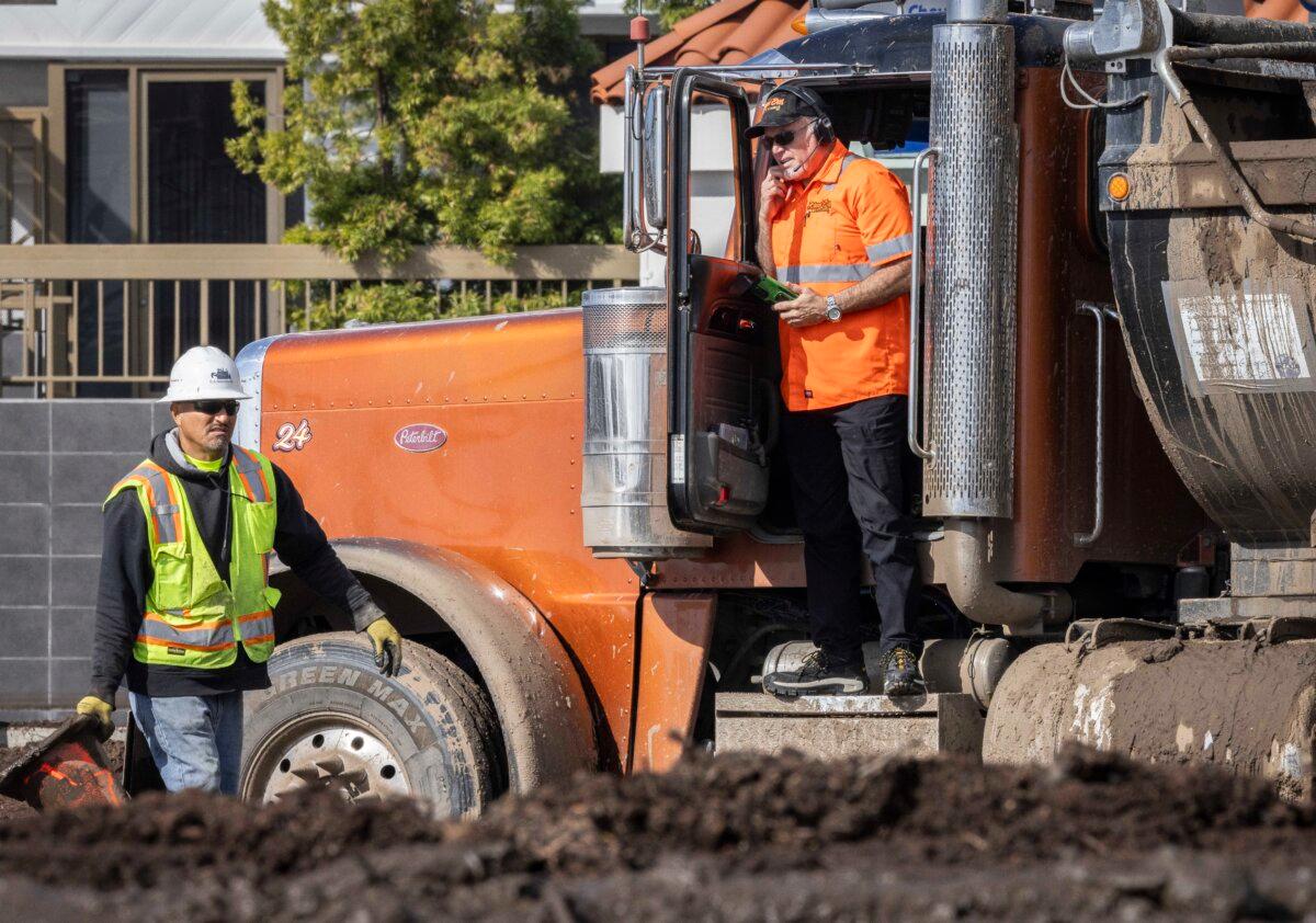 After the Palisades Fire, first responders and clean-up crews clear mud and debris flows caused by heavy rains along Pacific Coast Highway near Los Angeles on Feb. 14, 2024. (John Fredricks/The Epoch Times)