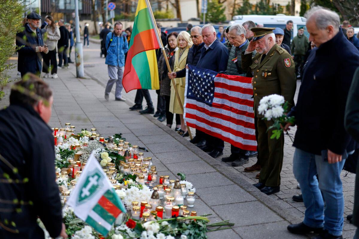 4th Missing US Soldier Found Dead in Lithuania | USNN World News People with U.S. national flag come to pay their last respect to the three soldiers found dead on Monday at a training range in Pabrade, near the U.S. Embassy in Vilnius, Lithuania, on April 1, 2025. (Mindaugas Kulbis/AP Photo)