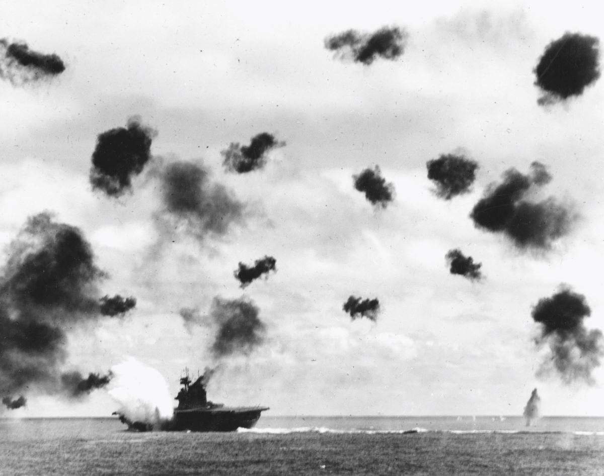 USS Yorktown (CV-5) is hit on the port side by a Japanese Type 91 aerial torpedo during the mid-afternoon attack by planes from the carrier Hiryu, in the Battle of Midway, on June 4, 1942. This is the second of the two torpedo hits it received. Note the very heavy antiaircraft fire. (Public Domain)