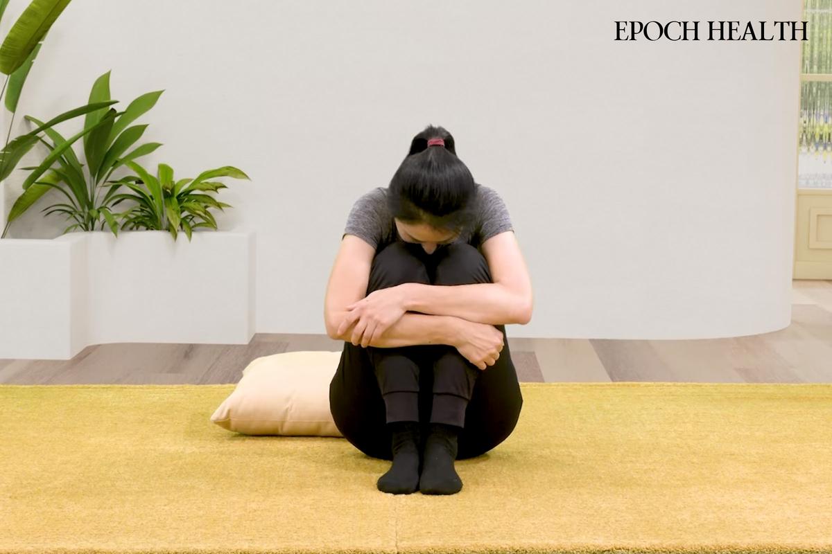 5 Effective Bedtime Stretches to Ease Back Pain | USNN World News Seated Knee Hug. (The Epoch Times)