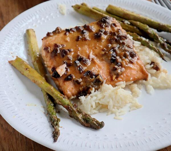 Salmon marinated in a savory mix of chopped dates, Dijon mustard, and white miso and then oven-roasted makes for an easy and elegant meal. (Gretchen McKay/Pittsburgh Post-Gazette/TNS)
