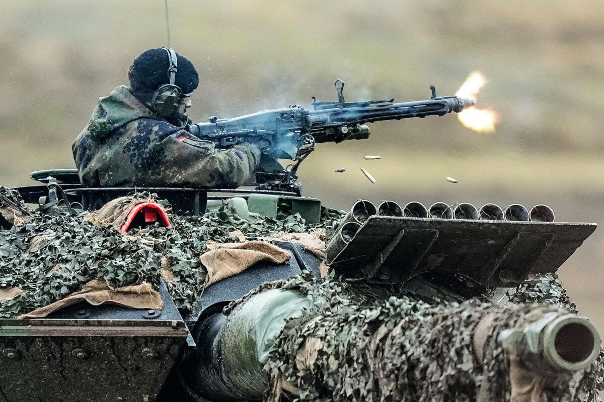 A soldier fires a machine gun from a Leopard 2 tank at the Bundeswehr tank battalion 203 at the Field Marshal Rommel Barracks in Augustdorf, Germany, on Feb. 1, 2023. (Martin Meissner/AP Photo)