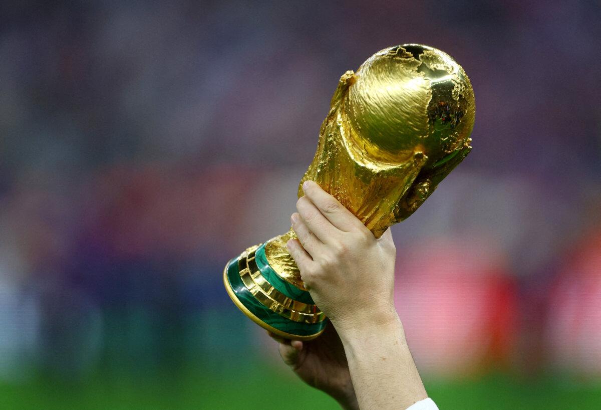 A player holding the World Cup trophy during the closing ceremony of the World Cup final soccer match between Argentina and France at the Lusail Stadium, Qatar, on Dec. 18, 2022. (Hannah Mckay/Reuters)