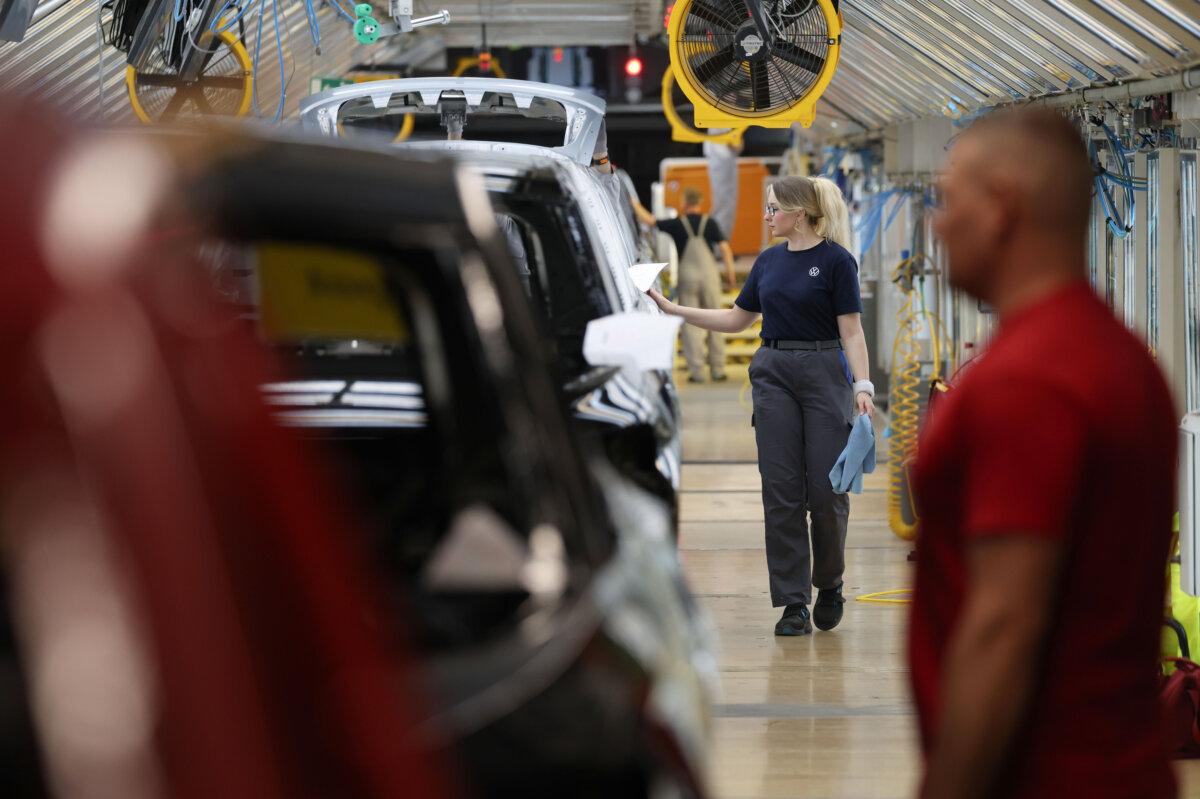Workers do a quality control check on paint on cars at the Volkswagen automobile factory in Wolfsburg, Germany, on March 7, 2025. (Sean Gallup/Getty Images)