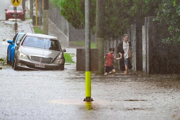 Residents walk in a flooded street in the suburb of Nundah in Brisbane, Australia, on March 09, 2025. (Albert Perez/Getty Images)