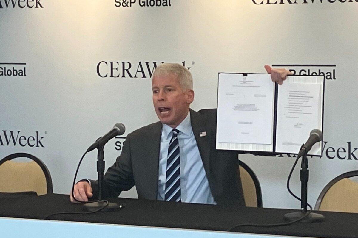United States Energy Secretary Chris Wright displays the order he signed in March at CERAWeek by S&P Global in Houston approving Delfin LNG’s permit to begin exporting LNG from its offshore Louisiana terminal by 2029. (John Haughey/The Epoch Times)