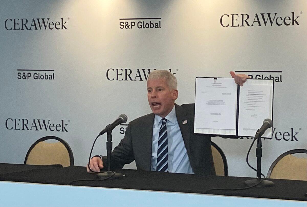 United States Energy Secretary Chris Wright displays the order he just signed approving Delfin LNG LLCâs permit through June 2029 to begin exporting LNG from its offshore Louisiana terminal. (John Haughey/The Epoch Times)