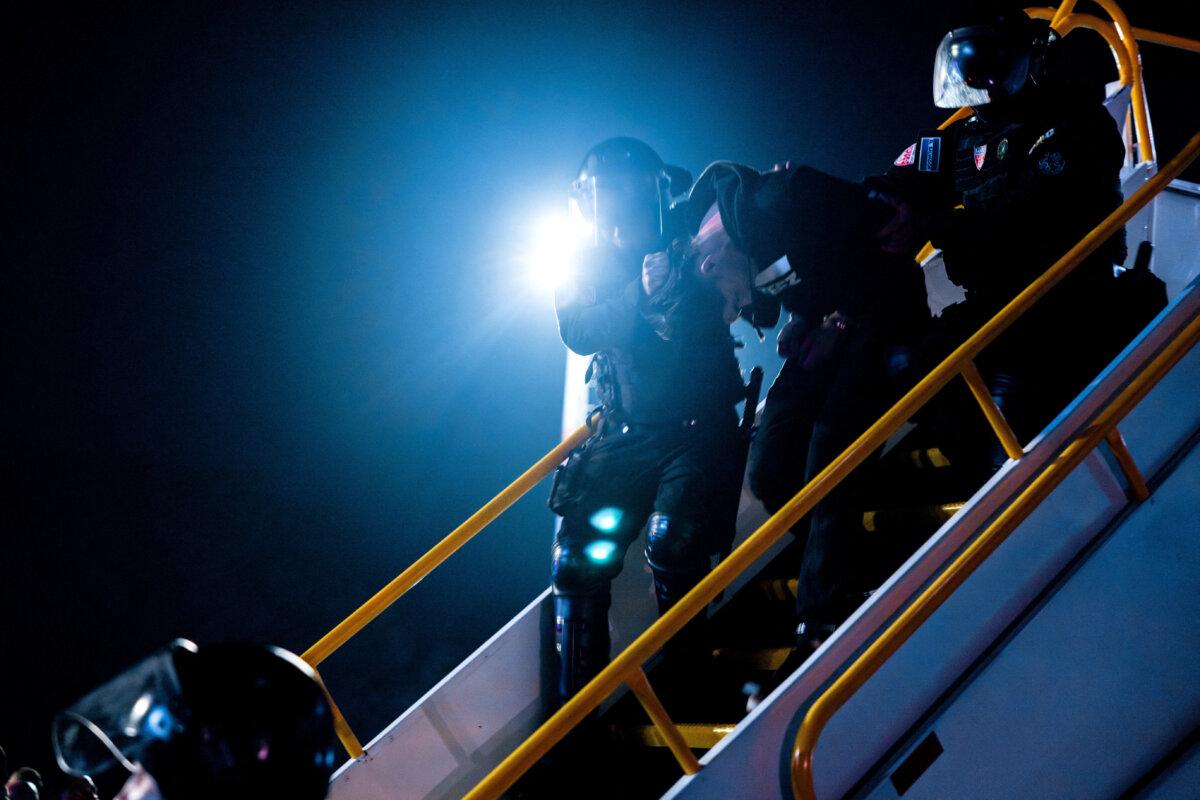 Salvadoran police officers escort alleged members of the Tren de Aragua recently deported by the U.S. government to be imprisoned in the Terrorism Confinement Center (CECOT) prison, as part of an agreement with the Salvadoran government, at the San Oscar Arnulfo Romero international airport in San Luis Talpa, El Salvador, in this handout image obtained March 16, 2025. (Secretaria de Prensa de la Presidencia/Handout via Reuters)