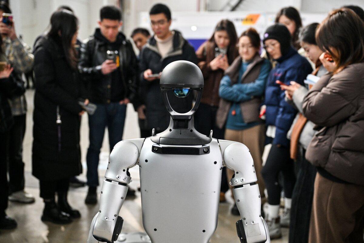 People stand next to a humanoid robot at an AI conference in Shanghai on Feb. 21, 2025. (Hector Retamal/AFP via Getty Images)