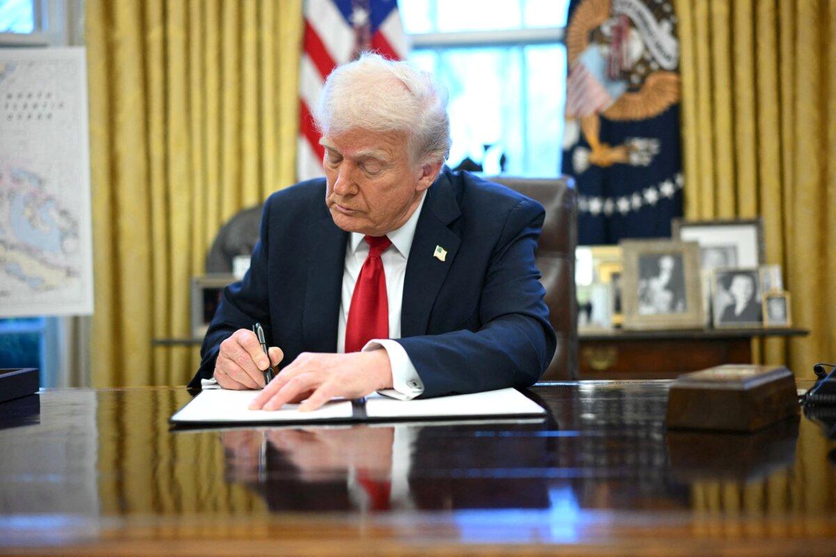 U.S. President Donald Trump signs an executive order announcing tariffs on auto imports in the Oval Office of the White House in Washington, on March 26, 2025. (Mandel Ngan/AFP)
