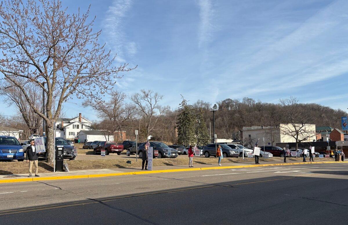 Supporters of Susan Crawford, a Democrat-backed candidate for the Wisconsin Supreme Court, hold up signs to drivers in Hudson, Wis., on March 27, 2025. (Nathan Worcester/The Epoch Times)