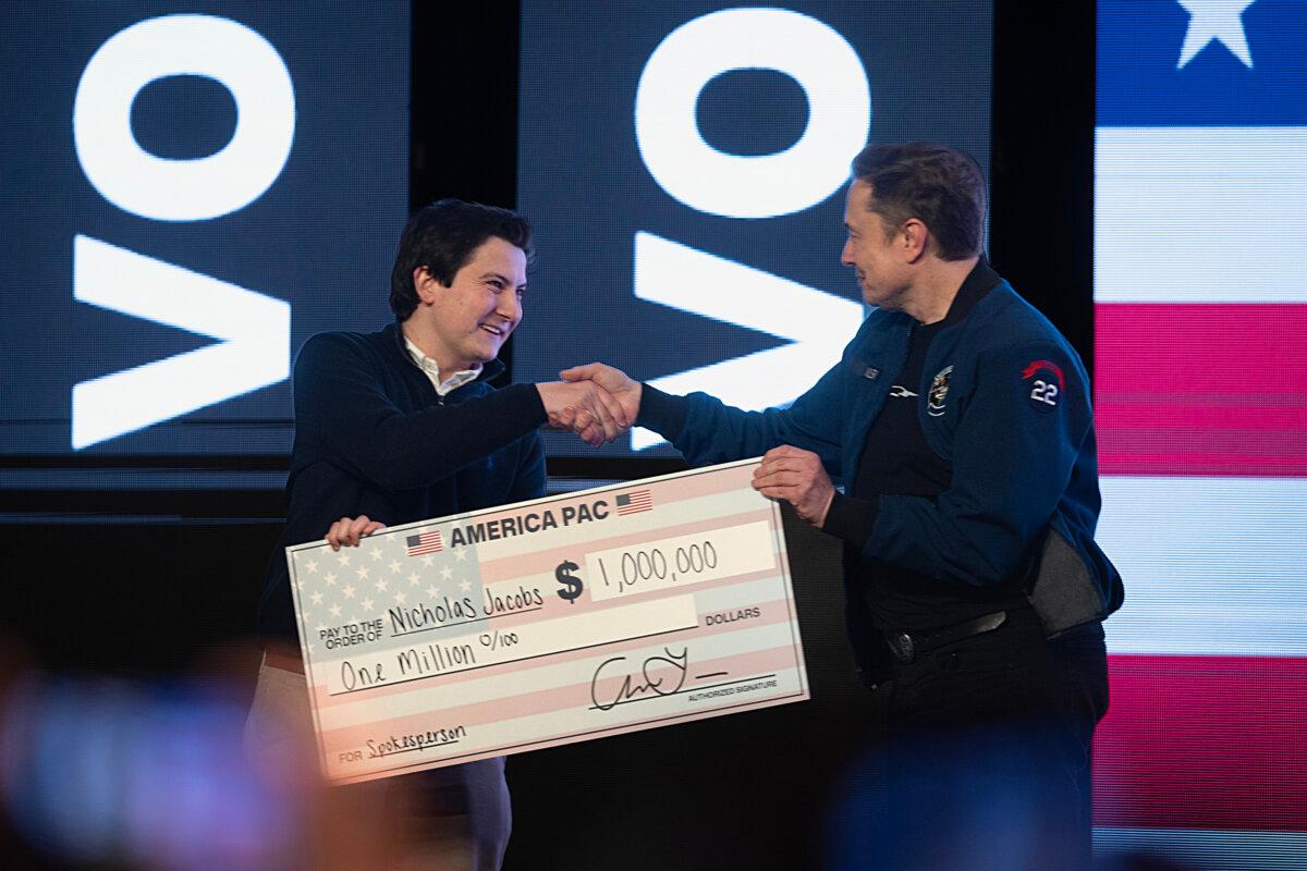 Elon Musk gives $1 million to Wisconsin voter Nicholas Jacobs during a town hall meeting at the KI Convention Center in Green Bay, Wis., on March 30, 2025.  (Scott Olson/Getty Images)