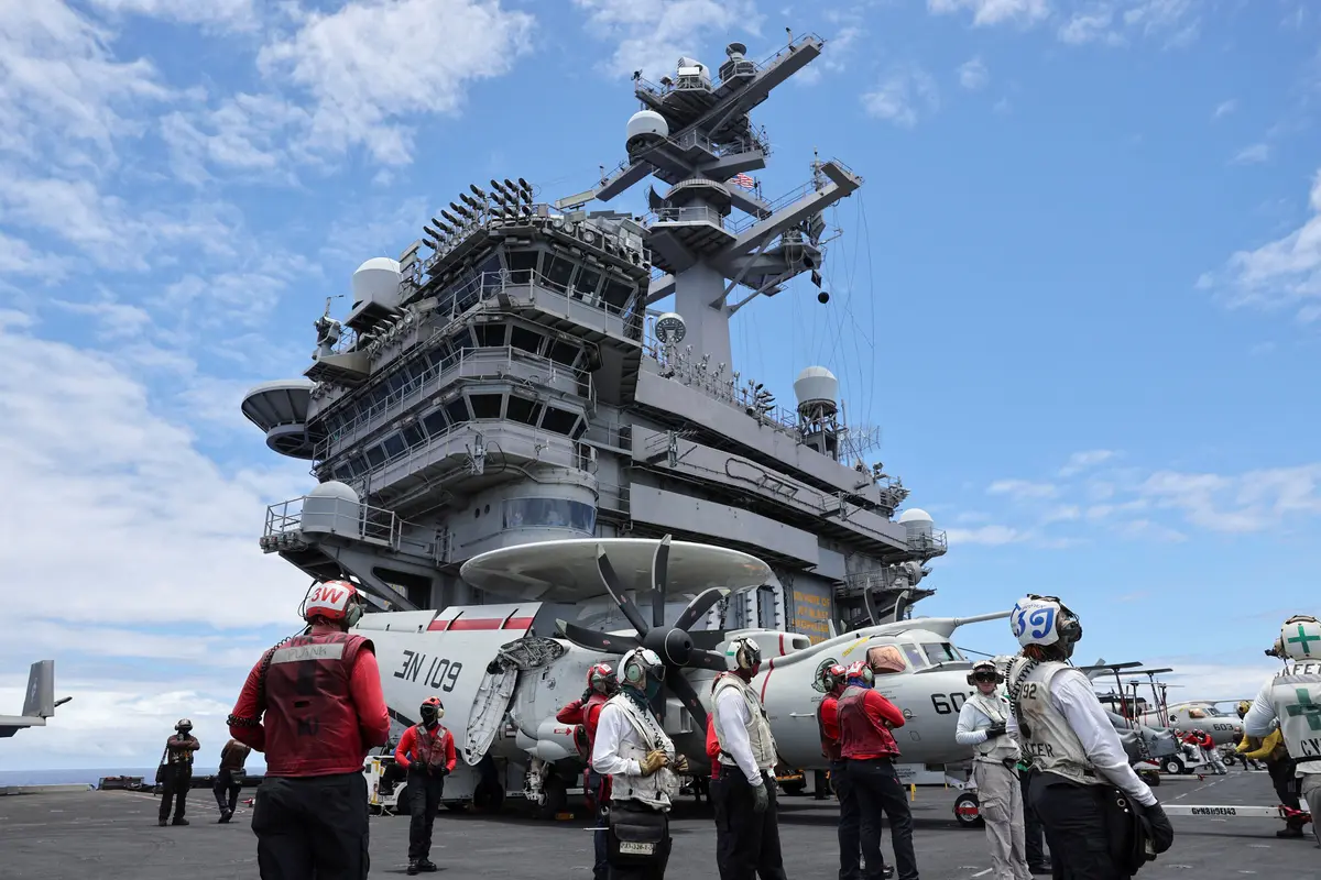 Flight deck crew members watch jets take off from the USS Carl Vinson aircraft carrier during the Rim of the Pacific (RIMPAC) military exercises about 100 miles south of Oahu, Hawaii, on July 19, 2024. (Marco Garcia/File Photo/Reuters)