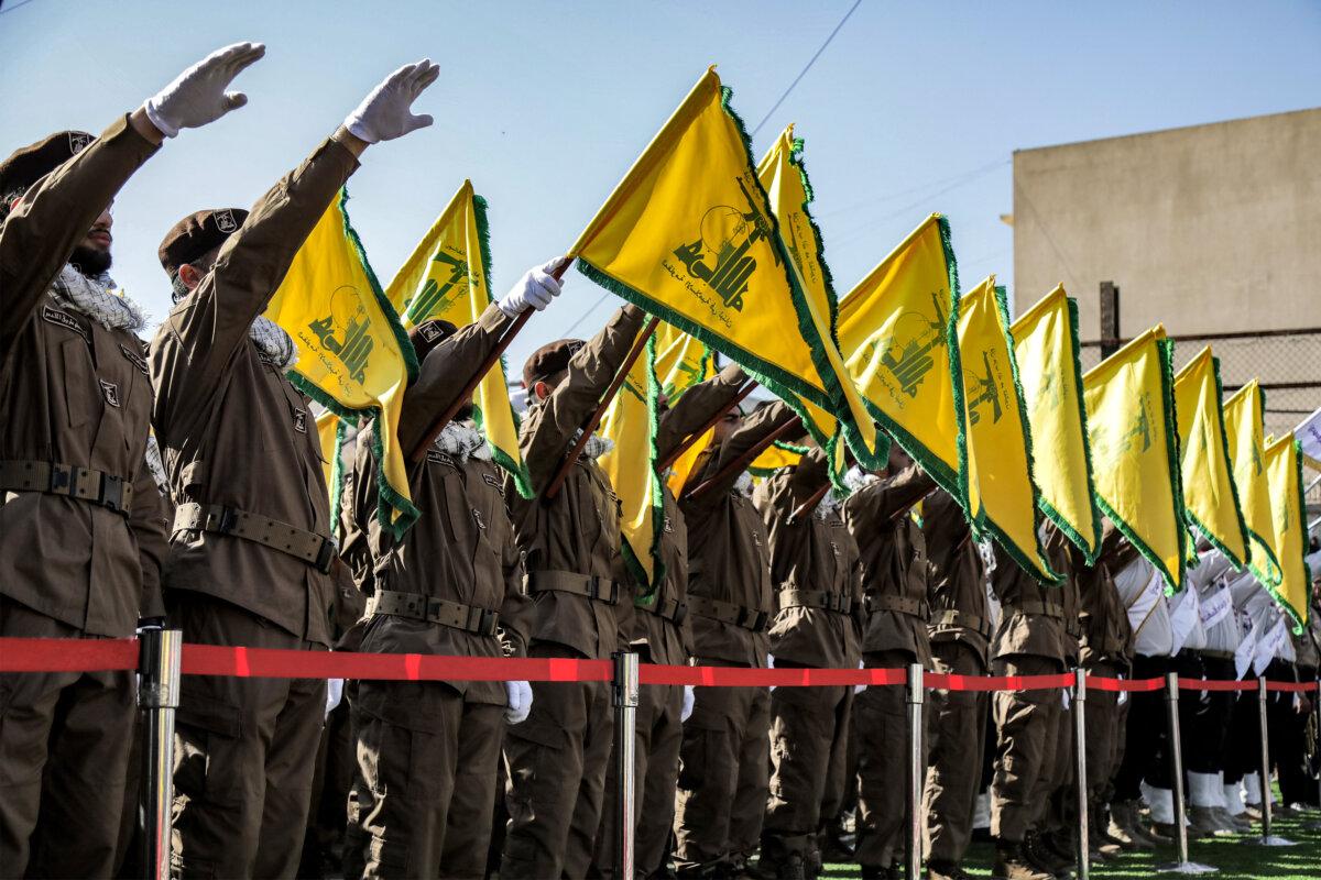 Hezbollah members salute and raise the group's yellow flags during the funeral of their comrades killed in an Israeli strike on their vehicles, in Shehabiya, Lebanon, on April 17, 2024. (AFP via Getty Images)