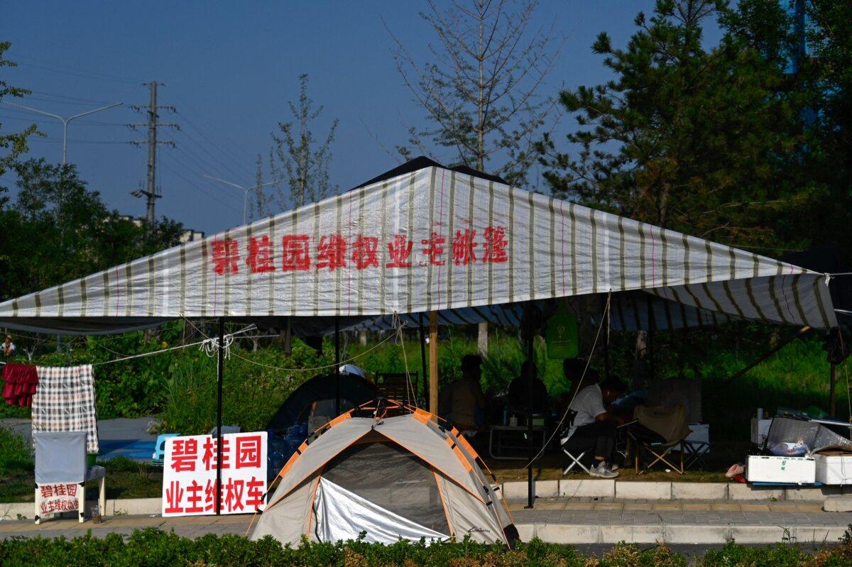People protest next to a development of property developer Country Garden in Beijing, China, on Aug. 15, 2023. (PEDRO PARDO/AFP via Getty Images)