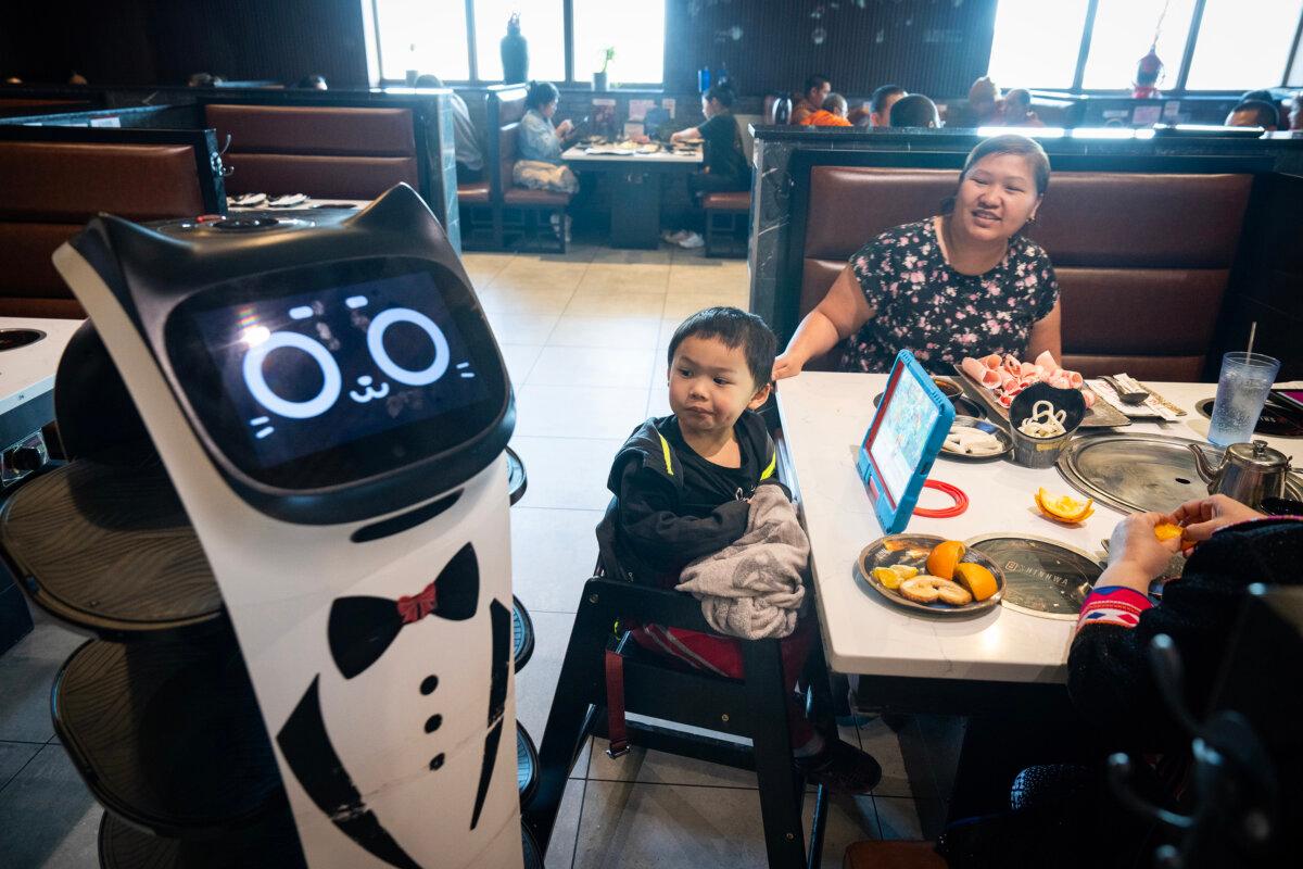 Genesis Mijares, 4, and his mother Xai Mijares watch as a robot server leaves their table after delivering food at Shinhwa Korean Steakhouse in Roseville, Minnesota, on Tuesday, March 11, 2025. (Leila Navidi/The Minnesota Star Tribune/TNS)