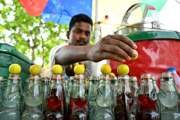 A vendor selling lemon soda takes shelter under a tree on a hot summer day along a road in Amritsar, India, on April 19, 2025. (Narinder Nanu/AFP via Getty Images)
