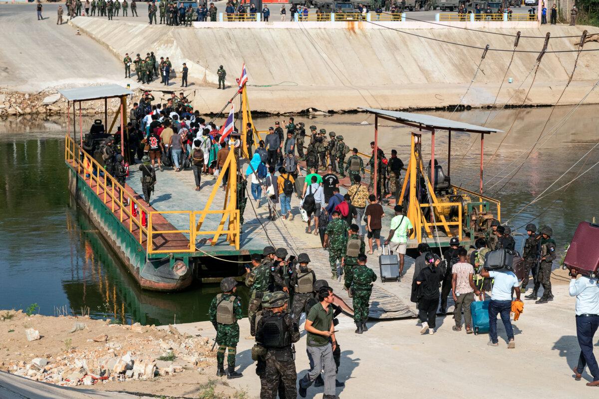 Victims of scam centers board a boat to cross the river into Thailand on the Burma–Thai border, in Myawaddy, Burma, on Feb. 12, 2025. (STR/AFP via Getty Images)